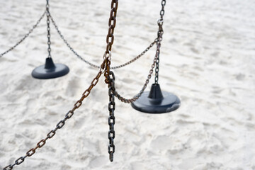 empty and broken swing on the beach with sea fog, corona lockdown, loneliness, alone, where are the kids