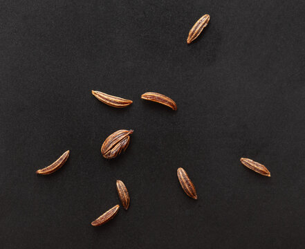 Close up of cumin seeds on a black background.