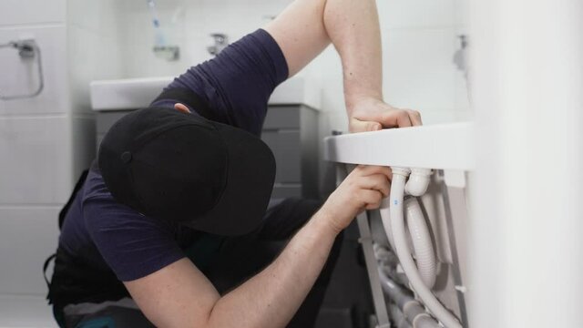 Man installing pipe system of bathtub with hydromassage.