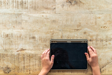 Overhead view of blank tablet device in child's hands