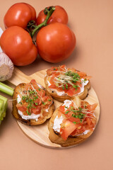 Bruschetta with Tomatoes Cheese and Herbs on Toasted Garlic Cheese Bread on Wooden Tray Orange Background