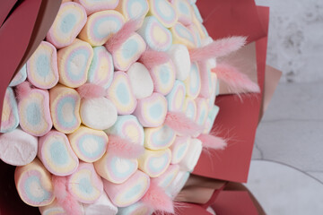 Sweet bouquet of Marshmallows sweets, beautifully decorated, lies on a gray background..Holiday concept, congratulations.