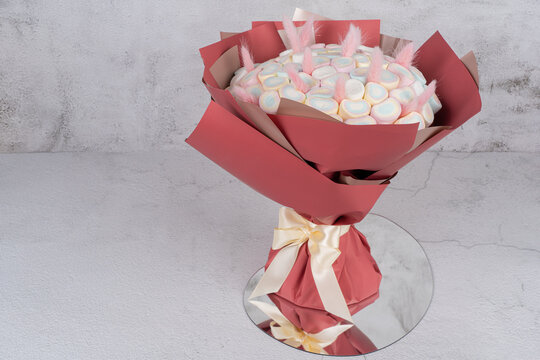 Sweet bouquet of Marshmallows sweets, beautifully decorated, lies on a gray background. There is a place for text.Holiday concept, congratulations.