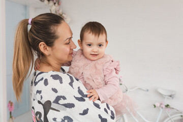 young mother holds her daughter 1 year old. family well-being and relationship psychology concept