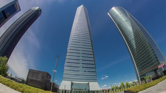 Skyscrapers timelapse hyperlapse in the Four Towers Business Area with the tallest skyscrapers in Madrid and Spain. Blue sky with clouds. fisheye