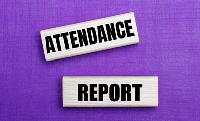 On a lilac bright background, light wooden blocks with the text ATTENDANCE REPORT