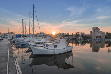 Port of charming Aegina town with yachts and fishermen boats docked in Aegina island, Saronic gulf, Greece, at sunset.