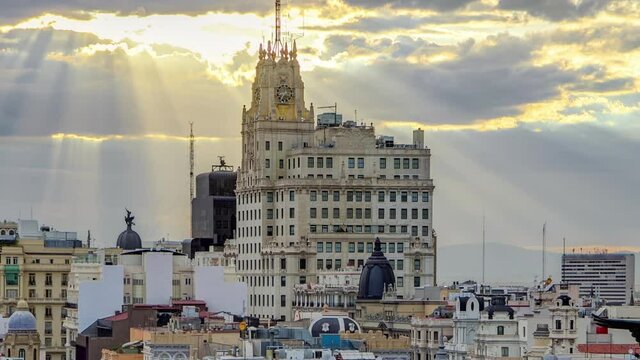 Telefonica Building is a Manhattan-style skyscraper at Gran Via timelapse with rays of sun at sunset time, Madrid, Spain. Telefonica Building is the tallest building in downtown Madrid rooftop aerial