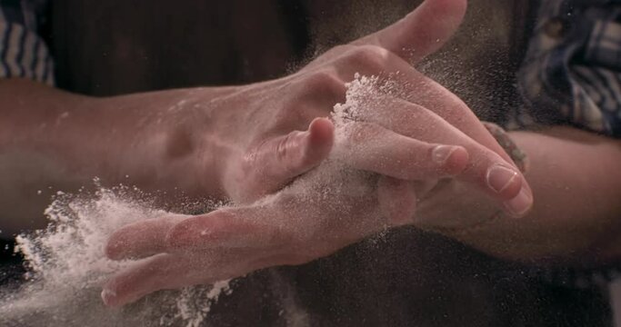 SUPER SLOW MOTION Woman chief cook clapping and sprinkling flour over dough on table. Shot with high speed camera at 720 FPS
