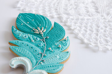 Sweet pastries. Dessert for tea. Easter gingerbread in form of feather on white background. Souvenir cookies as gift