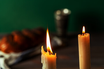 Shabbat Shalom. Challah bread, shabbat wine and candles on wooden table.