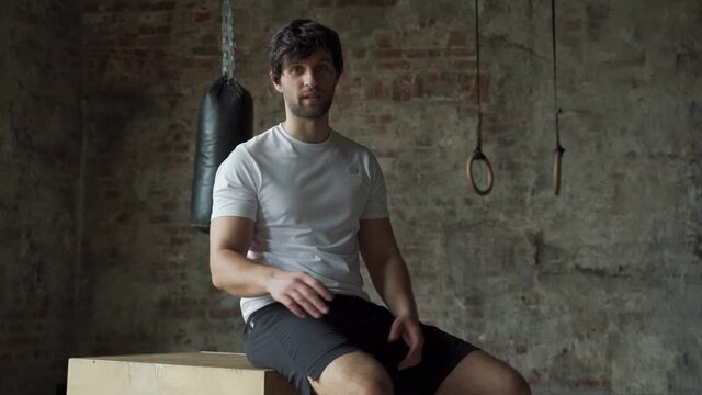 Professional bodybuilder man instructor speaking at camera motivation for sports in gym