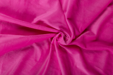 Colored rose textile satin fabric folded in folds and waves with highlights and texture