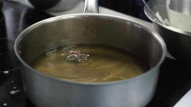 Deep frying delicious meatballs in hot oil in professional kitchen