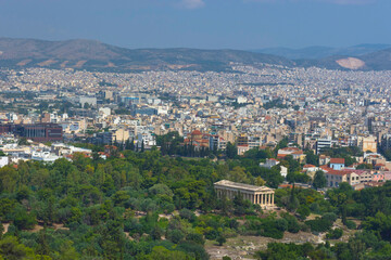 Fototapeta na wymiar View of the Athens and the ancient Temple of Hephaestus, a doric greek temple in the north-west side of the Agora of Athens, Greece.