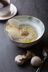 Prepared creamy mushroom soup served on a black table
