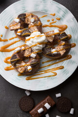 Donuts with caramel, chocolate and cookies on a plate