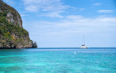 Landscape background for vacation. Beautiful tropical beach with island in Thailand. Blue sky with cloudy on sunny summer season. Seascape with small island and yacht. Relaxation, lifestyle concept.