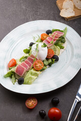 Fresh tuna salad served with poached egg on a plate