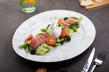 Fresh tuna salad served with poached egg on a plate