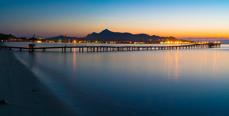 Panorama of a wooden pier on the seashore during sunset