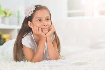 little cute girl reading book  at home