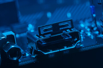High tech dark background with elements of a computer motherboard in soft focus under high magnification. Video connector hdmi on the home computer board.