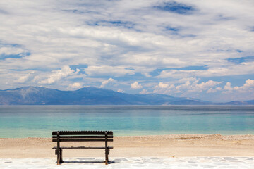 Empty wooden bench by the sea in a cloudy day, gazing the Corinthian gulf, near Xylokastro town, in...