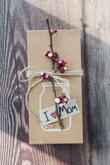 Handmade craft box gifts with painted vase and bouquet of spring branches and flowers on wooden...