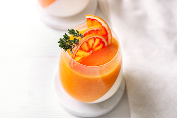 Orange dessert panna cotta with thyme and orange slices on a white plate, horizontal orientation,...