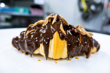  almond stick chocolate croissant on white plate