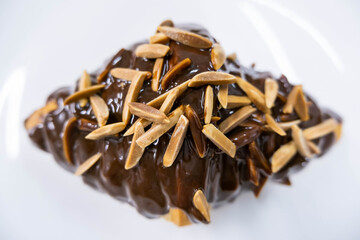  almond stick chocolate croissant on white plate