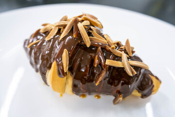 almond stick chocolate croissant on white plate
