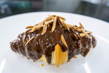  almond stick chocolate croissant on white plate
