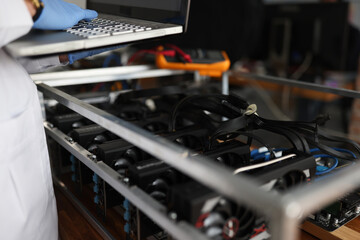 Master checking cryptocurrency mining rig using graphic cards closeup