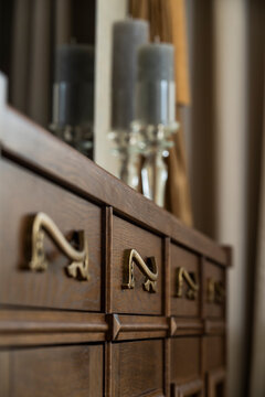 bronze handle on the chest of drawers in the interior, an element of the interior of wooden furniture
