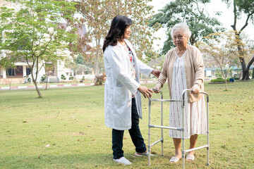 Doctor help and care Asian senior or elderly old lady woman use walker with strong health while walking at park in happy fresh holiday.