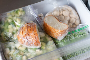 Frozen bread in the home freezer, baguette in reserve on a shelf of a home freezer, long food...
