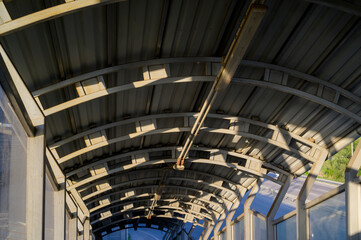 metal outdoor canopy for protection from the sun and bad weather with lamps on the ceiling, industrial roof for pedestrian safety