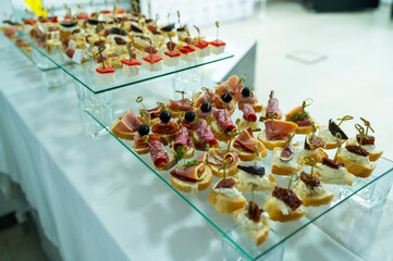 canapes with cheese and pieces of sausage and bacon, snacks at the reception