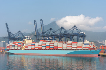 Cargo container ship berthed in port of Yantian. She is fully loaded with cargo inside containers,...