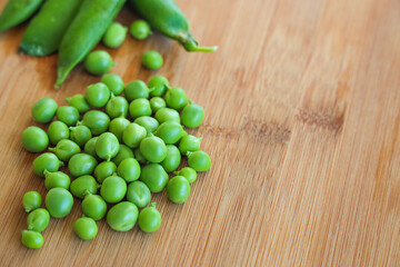 Selective Focus of Fresh raw green peas grains on wooden background, Food Concept, Copy Space.