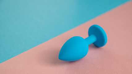 Blue anal plug on a pink background. Plastic sex toy for alternative sex. Copy space.