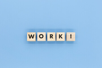 Square wooden blocks with text WORK on top isolated on blue background , Top view
