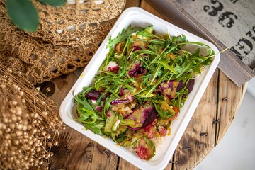 food delivery to office or for picnic in disposable plastic dishes. salad with rucola beetroot and...