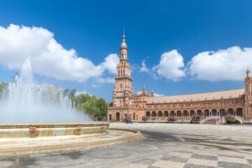 Fountain on Plaza de España. In background beautiful architecture Espana Square. Touristic travel attraction in the center of Seville , empty now due to the Coronavirus measures of isolation. 