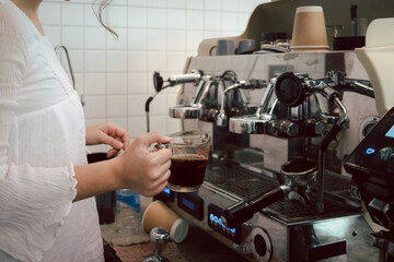 Barista staff prepare coffee, woking with coffee machine in coffee shop counter bar.