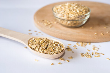 wooden spoon and plate with oatmeal on white