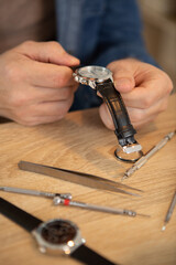 watchmaker in his workshop repairing a wrist watch