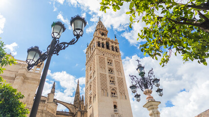 Fototapeta na wymiar The Giralda tower in Seville, bell tower of the cathedral. Panoramic photograph on a sunny spring day.